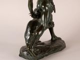 bronze statue of a man holding a bird on a rock