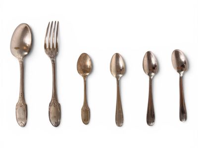 several spoons, forks and spoons are lined up on a white surface