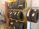 tires are stacked on a rack in a tire shop