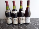 quatre bouteilles de vin sont alignées sur une table
