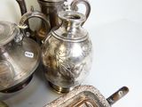 de nombreuses théières et plateaux en argent posés sur une table