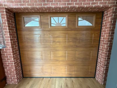 une photo d'une porte de garage en bois dans un bâtiment en briques