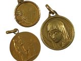 three gold medals with a woman ' s face and a man ' s head