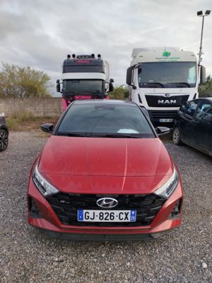 une voiture rouge garée à côté d'un camion