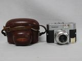 un appareil photo marron et un sac marron sur fond blanc