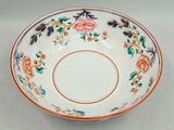 a white bowl with orange and blue flowers on it