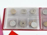 a box of coins sitting on a table next to a red envelope