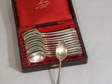 une boîte de cuillères en argent et des cuillères posées sur une table