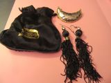 un sac noir avec une paire de boucles d'oreilles à côté