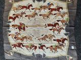 un gros plan sur un foulard carré orné de chevaux et de jockeys