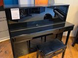 un piano noir et un tabouret dans une pièce aux murs bleus