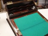 a small wooden box with a green mat on it
