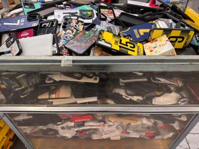 une boîte en métal posée par terre et remplie d'objets divers