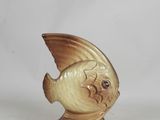 a small figurine of a fish on a stand