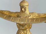 a gold statue of a man holding a sword