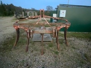 une structure métallique rouillée au milieu d'un champ