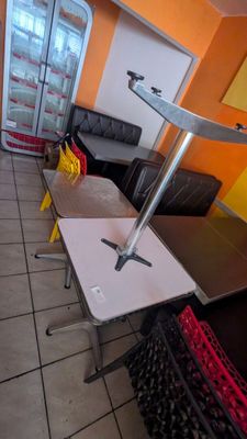 a room with a table, couch, and refrigerator in it