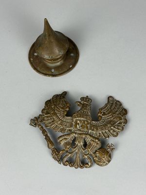un petit objet métallique posé sur une table, à côté d'un chapeau