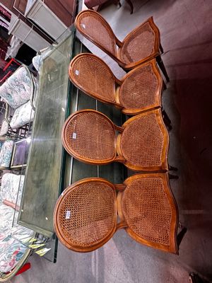 beaucoup de chaises en osier et une table en verre dans une pièce
