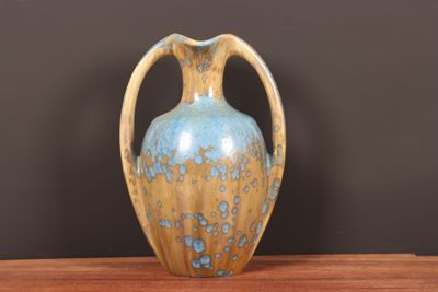 un vase bleu et jaune posé sur une table en bois