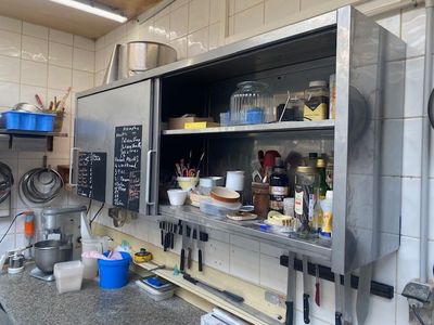 de nombreuses casseroles et poêles sur les étagères de la cuisine