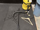 un aspirateur jaune et un seau bleu posés par terre