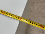 a measuring tape on top of a piece of white furniture