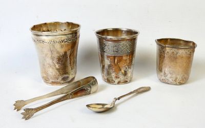 une tasse, une cuillère et un repose-cuillère en argent posés sur une surface blanche