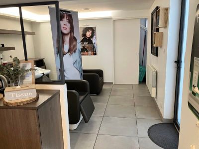 une photo d'un salon avec des fauteuils et des affiches accrochées au mur