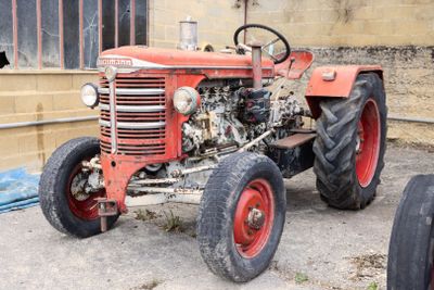 un tracteur rouge garé devant un bâtiment