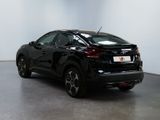 the rear of a black car is parked in a white room