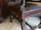 a wooden chair with a brown leather seat on a tile floor