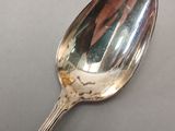a silver spoon with a reflection of a person on it