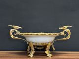 an image of a gold and white bowl sitting on top of a wooden table