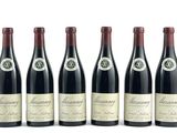 six bouteilles de vin sont alignées sur une surface blanche