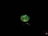 a close up of a green gemstone on a black surface