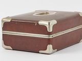 a small brown suitcase sitting on top of a white surface