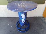 un tabouret bleu sur lequel est posée une bouteille de bière