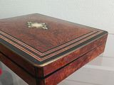 a small wooden box on display on a glass table