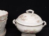 three pieces of china on a table with a black background