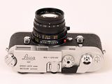an old camera with a lens attached to it on a white surface