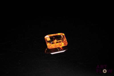 a close up of a yellow diamond on a black surface