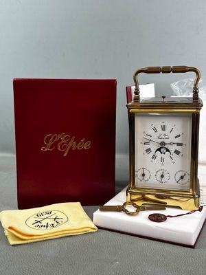 a small clock sitting on a table next to a box