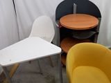 three chairs and a table in a room with a white curtain