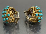 pair of turquoise and gold earrings on a black surface