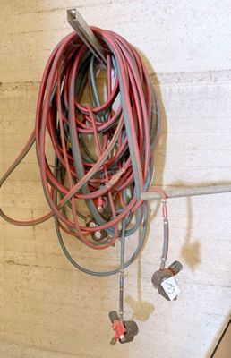 un tas de fils qui pendent du mur à côté d'une borne d'incendie