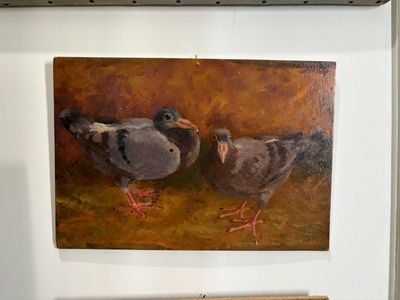two birds that are standing next to each other on the wall