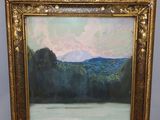 une peinture à l'huile représentant un lac et des montagnes, dans un cadre doré