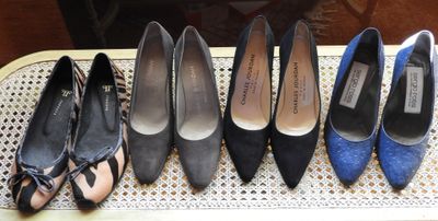 six pairs of women ' s shoes lined up in a row on a wicker chair