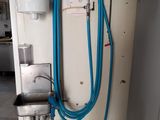 un tuyau bleu fixé au mur à côté d'un distributeur d'eau